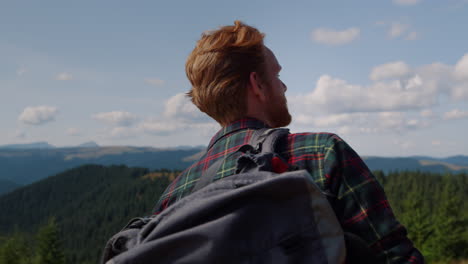 man with backpack walking in mountains