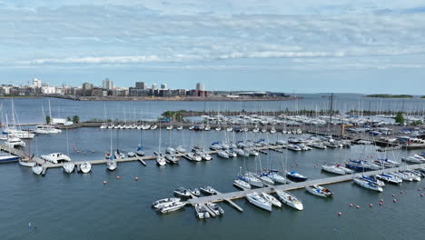 Toma-Aérea-En-Ascenso-Frente-Al-Puerto-Deportivo-De-Lauttasaari,-Día-De-Verano-En-Helsinki