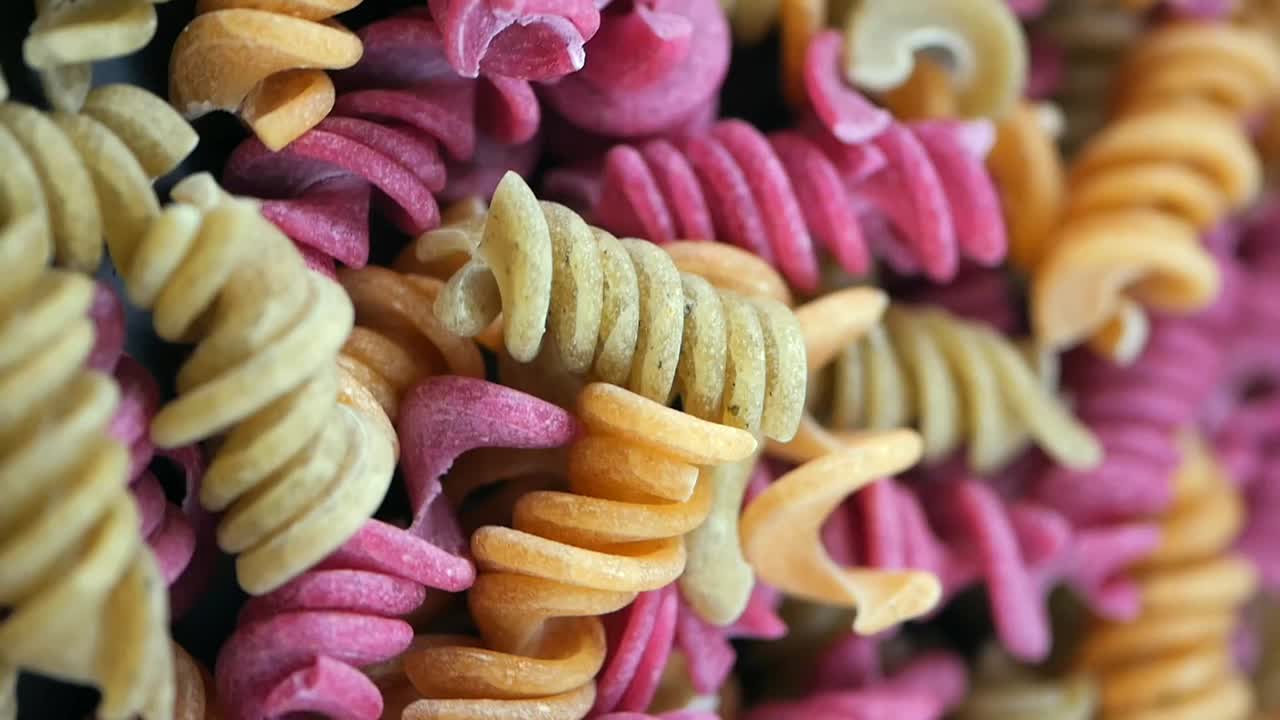 Primo piano di pasta fusilli colorata cruda