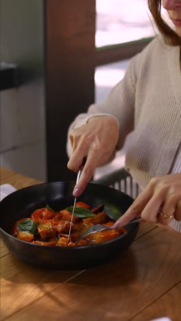 woman eating a delicious shrimp dish in a restaurant