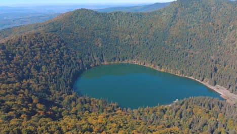 lake sfanta ana - saint anne crater lake with dense forest on a sunny day in autumn season in romania