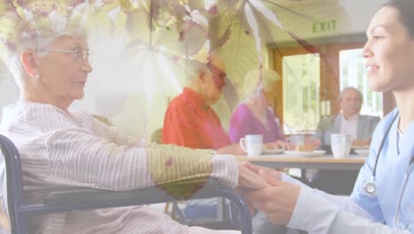 Animation-of-leaves-over-caucasian-nurse-with-senior-patient-in-wheelchair