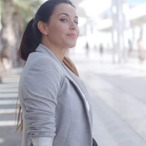 mujer elegante sentada en un banco en un paseo marítimo