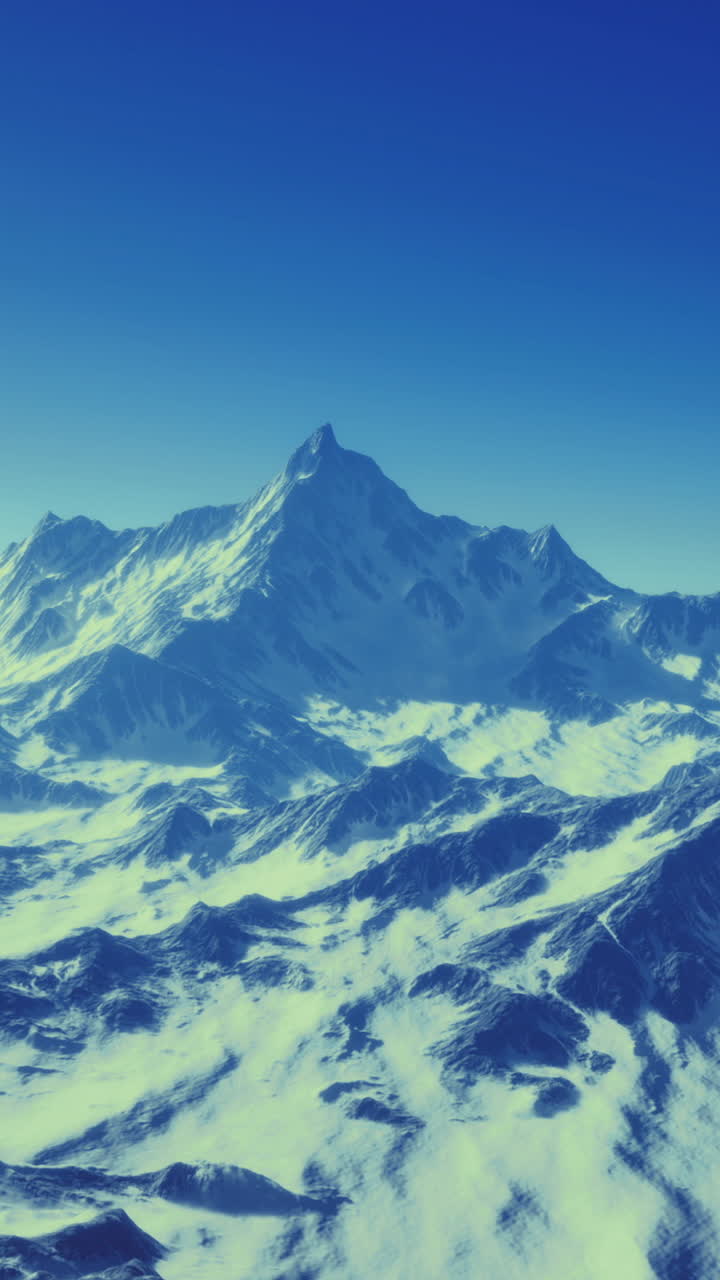 Snow capped mountain range under a clear blue sky at dawn