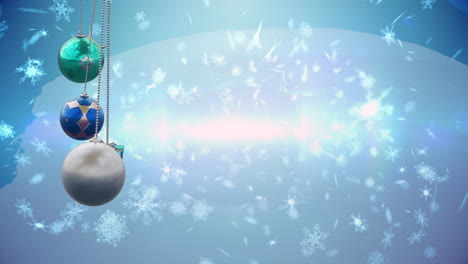 animation of christmas baubles over snow falling on blue background