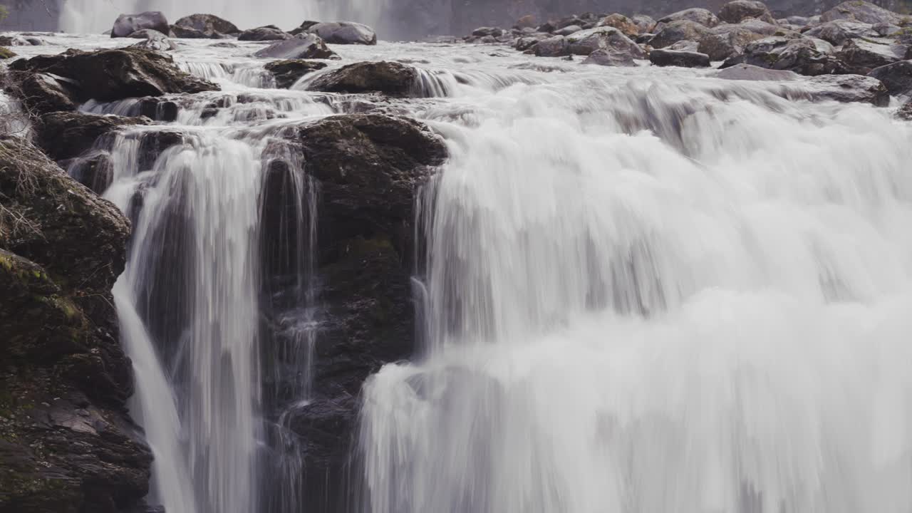 급류가 스토르포센 폭포의 어두운 바위 위로 계단식으로 흐르고 있습니다.