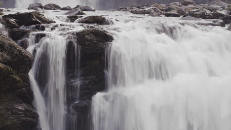 whitewater is cascading over the dark rocks at the storfossen waterfall