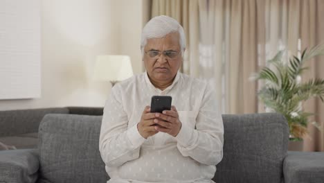 Angry-Indian-old-man-chatting-with-someone-on-phone