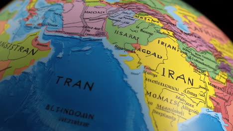 close-up view of a colorful world globe, focusing on central asia and iran.