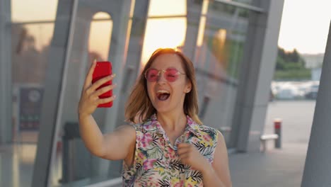 Tourist-girl-wearing-trendy-sunglasses-uses-phone.-Using-smartphone-for-call,-talk.-Trip,-tourism