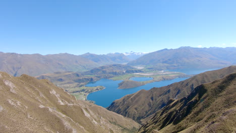 Weite-Malerische-Aussicht-Vom-Gipfel-Des-Roys-Peak-Auf-Den-Wanaka-See-Und-Die-Berge-Des-Mount-Aspiring-Nationalparks,-Schwenk-Von-Rechts-Nach-Links