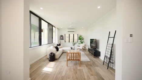 modern minimalistic wooden floored home small intimate lounge room area with sectional and black furniture pieces