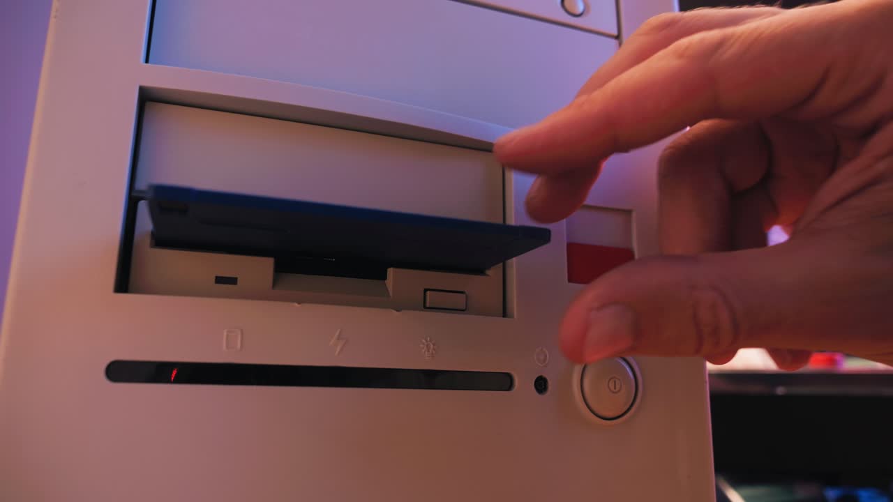 Using diskette for old computer. Music recorder, playing retro computer games. Vintage device for office, obsolete technology. . High quality 4k footage