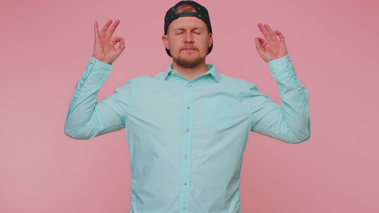 Man breathes deeply with mudra gesture eyes closed meditating with concentrated thoughts peaceful