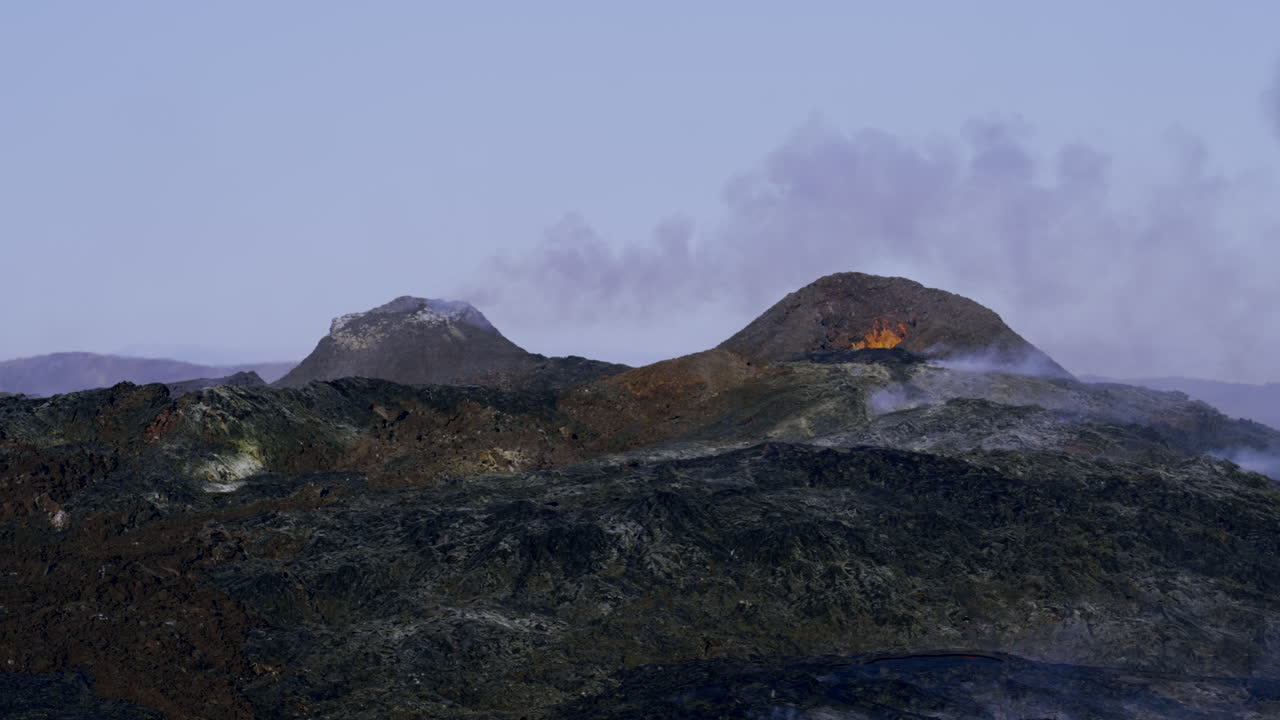분화 후 연기가 피어오르는 겔딩가달리르 화산 분화구의 마그마가 타오르고 분출하는 모습을 보여주는 와이드 샷