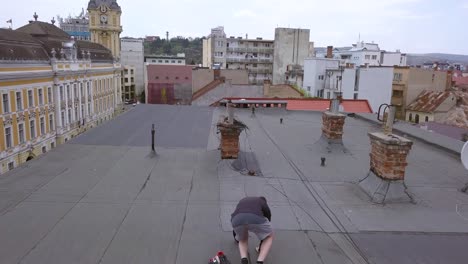 tracking shot of a young adult male walking on an abandoned roof top