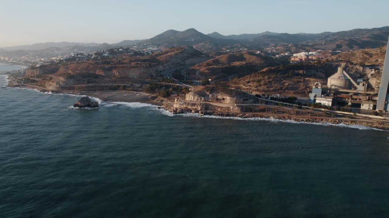 vuelo aéreo hacia la costa rocosa de málaga durante el atardecer dorado