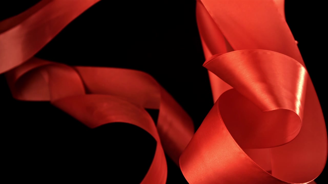 Elegante rote Satinbänder fließen auf schwarzem Hintergrund
