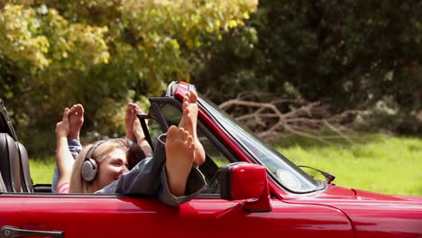 girls listening to music in a red car