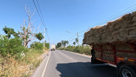 truck carrying oversized hay load on country road