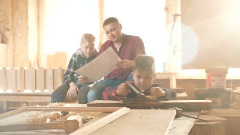 familia, carpintería, madera y concepto de la gente. el padre enseña a su hijo carpentería.