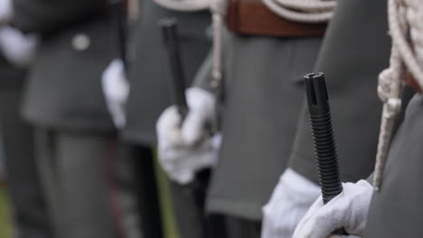 soldiers in formal uniforms with batons