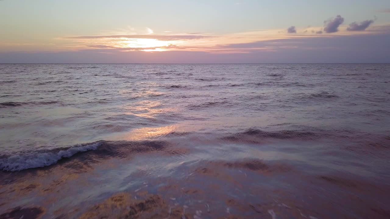 Beautiful aerial establishing view of Baltic sea coast on a sunny evening, sunset, golden hour, beach with white sand, coastal erosion, climate changes, low wide angle drone shot moving backward