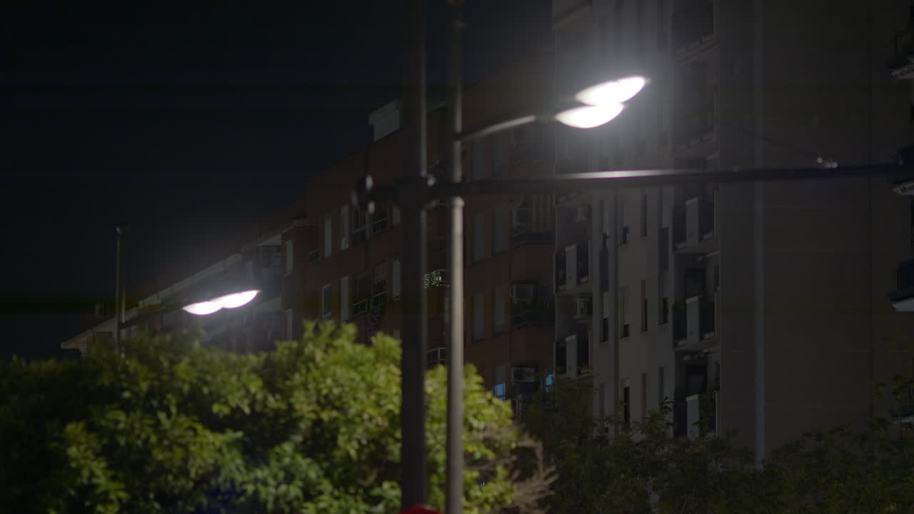 Cena urbana noturna com edifícios e postes de luz