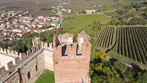 Orbitando-Sobre-La-Restaurada-Torre-Del-Castillo-De-Soave-Con-Bandera-Italiana