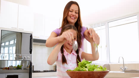 Mutter-Zeigt-Ihrer-Tochter,-Wie-Man-Einen-Salat-Mischt