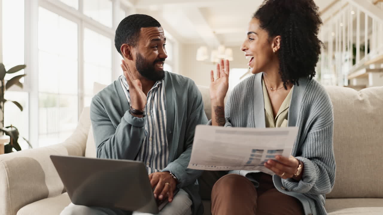 Couple planning finances at home with laptop and documents