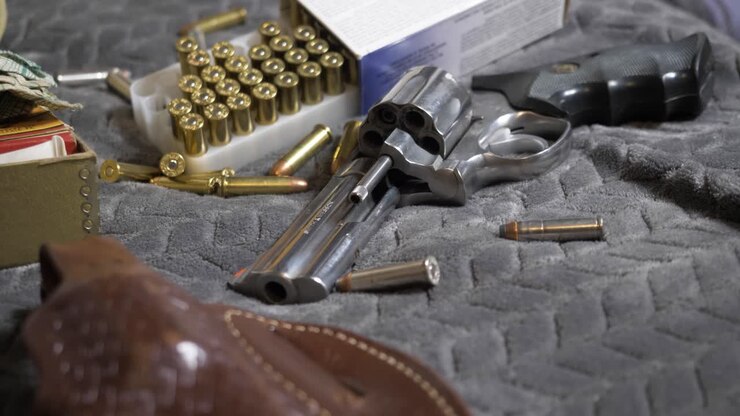 60p-Slomotion: Slow tilt up with focus pull from a leather bound holster to the barrel of a Handgun
