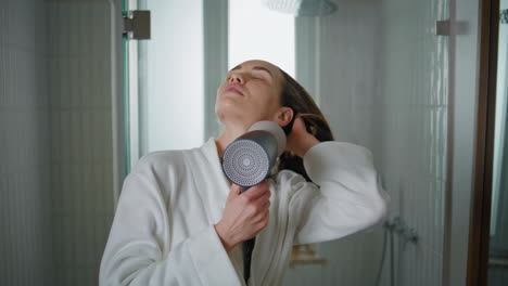 young woman drying hair at home closeup. serene lady getting ready in morning