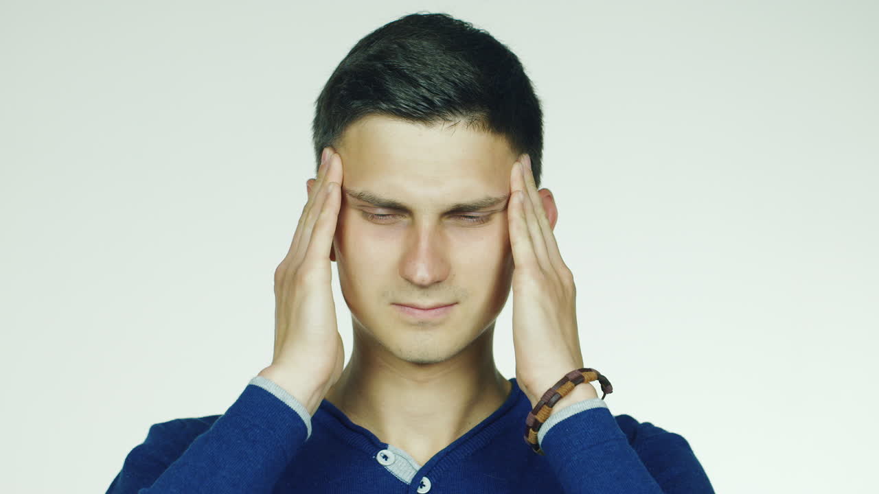 흰색 배경에 있는 스튜디오 비디오 그 남자는 두통이 있고 그녀는 미소를 짓는다.