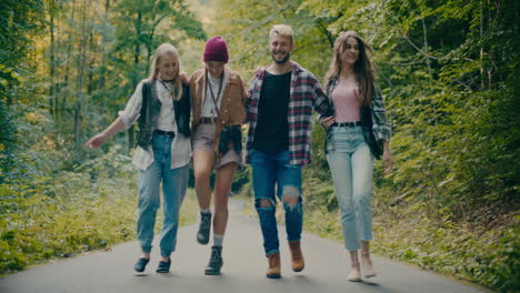 amigos felices caminando de brazos cruzados en el bosque.