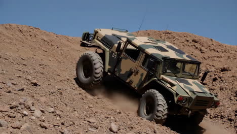 military vehicle climbing a desert hill