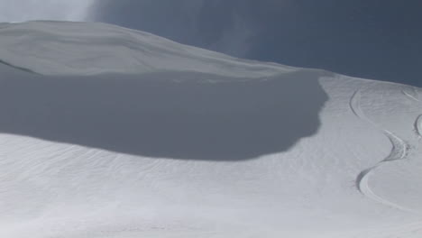 Longshot-of-a-snowboarder-moving-fast-down-a-slope