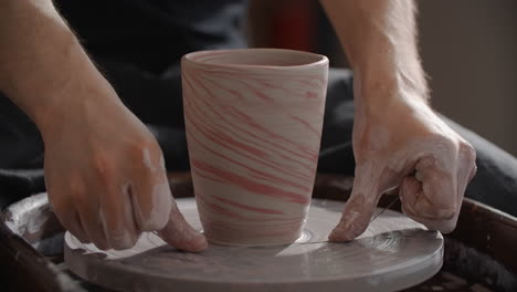 artisan creating a marbled ceramic cup on a pottery wheel