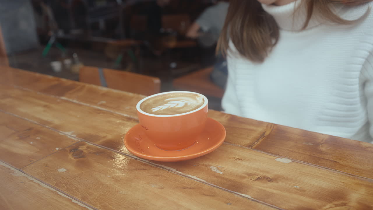 mujer disfrutando de un latte en un café