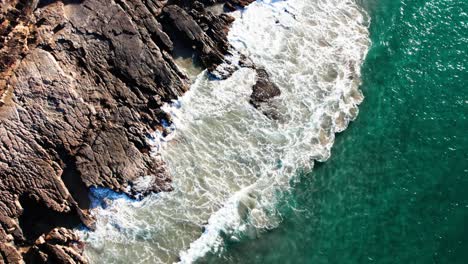 Vista-De-Pájaro-De-Las-Olas-Chapoteando-En-Acantilados-Escarpados-En-Noosa,-Queensland,-Australia---Disparo-De-Drone