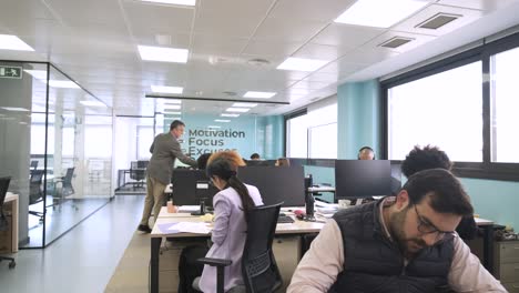 manager giving files to creative professionals in coworking workspace