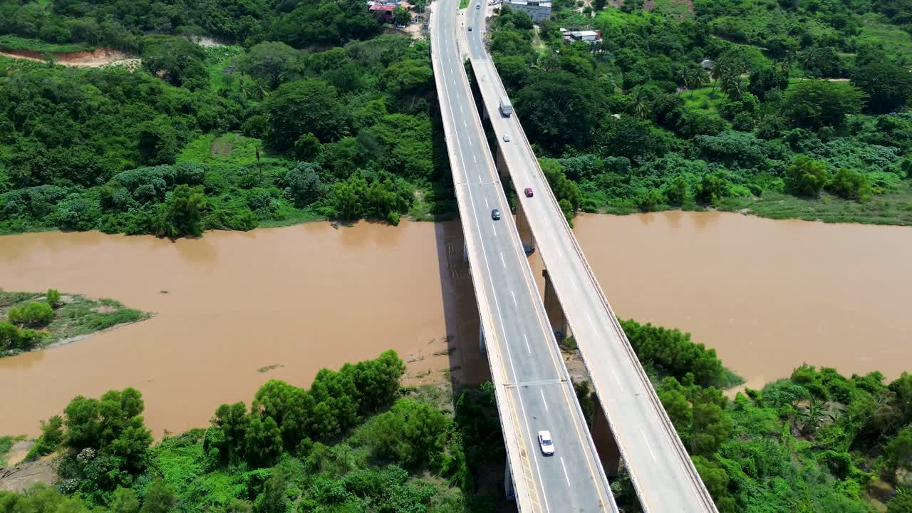 Drone aerial landscape of bus and car transport travelling over highway road bridge overpass Colotepec river creek in Puerto Escondido Mexico travel tourism