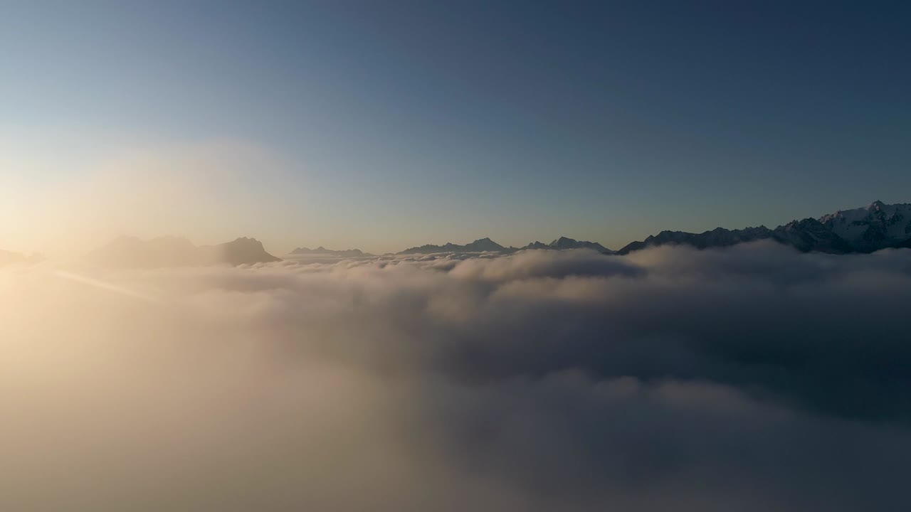 mountains above clouds. Aerial. Sunrise