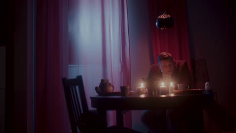 man sitting alone at a table at night