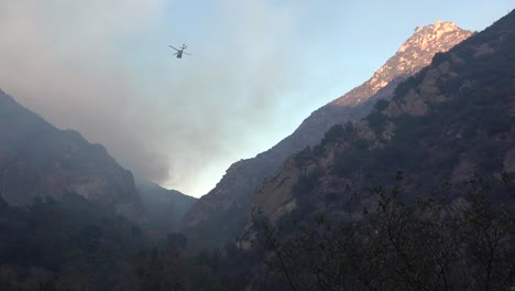 a helicopter makes water drops during the woolsey fire near malibu california