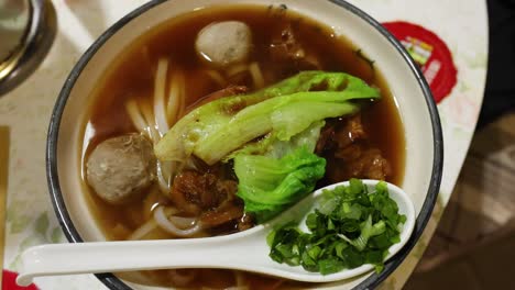 a bowl of beef noodle soup with vegetables