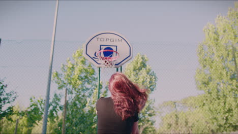 Rothaariges-Mädchen-Auf-Dem-Basketballplatz-Dribbelt-Den-Ball-In-Richtung-Korb-Und-Punktet