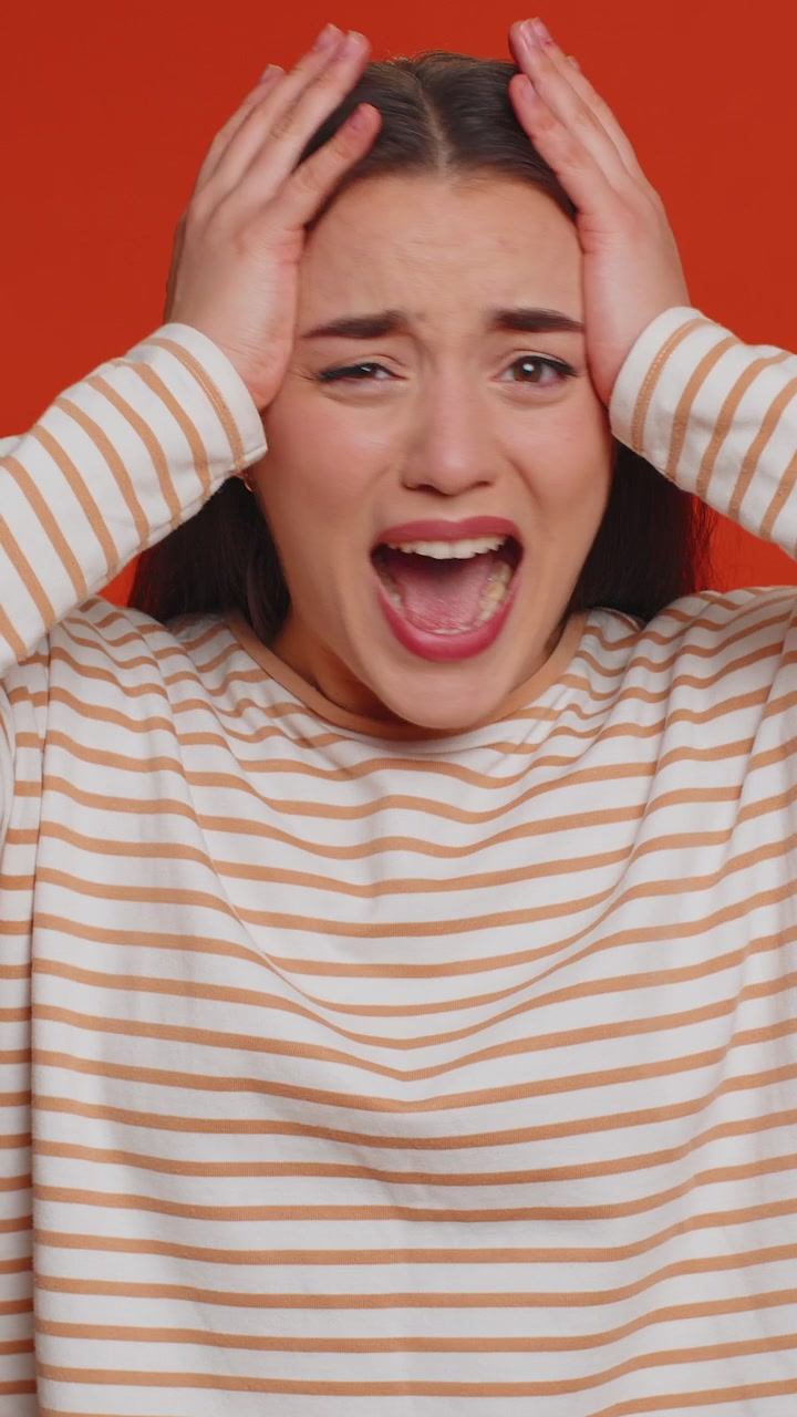 Una giovane donna urla a causa di problemi di stress e tensione, provando orrore, disperazione, paura, sorpresa, shock e rabbia.