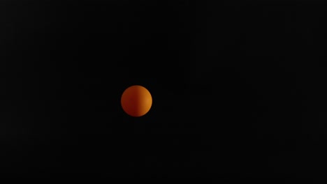 orange ball bouncing in a dark space