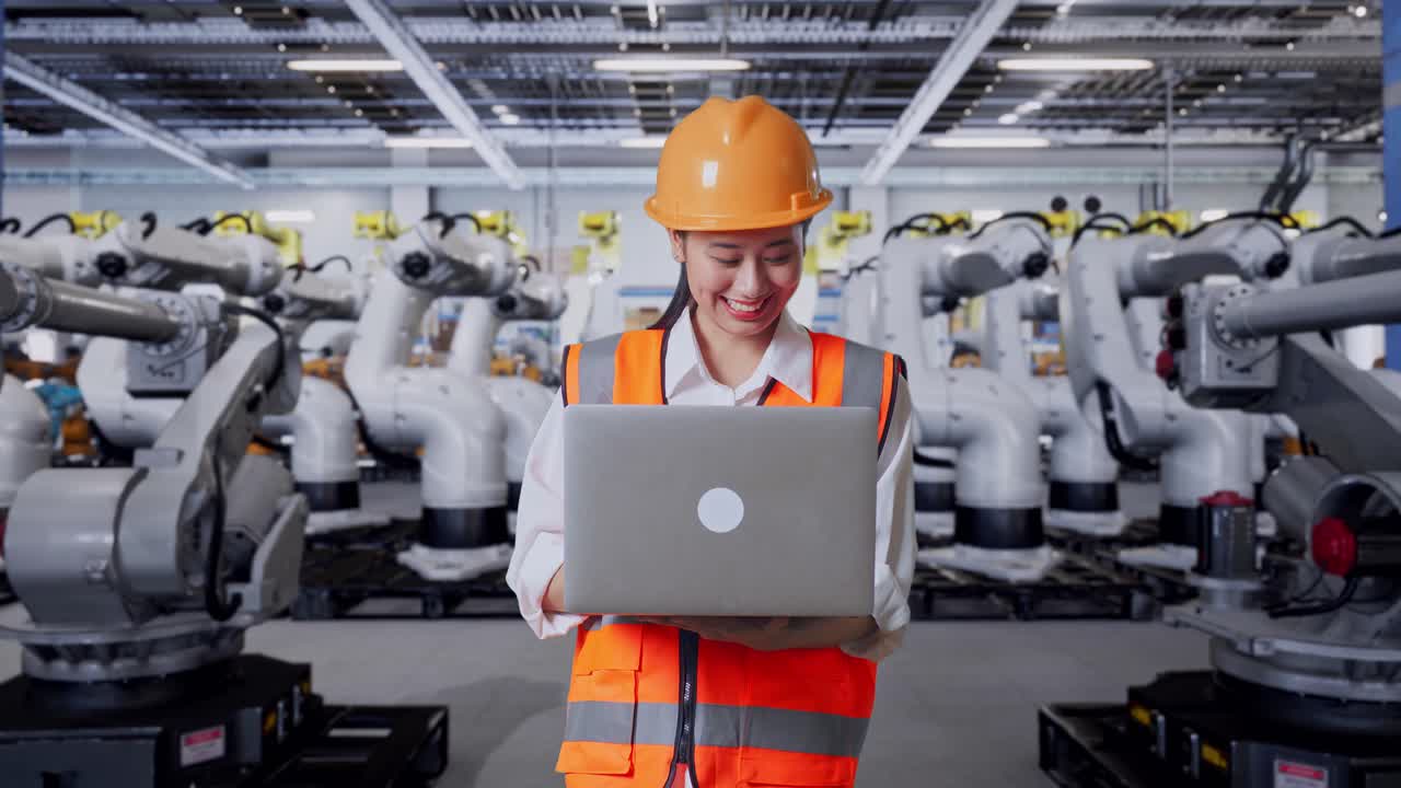 Engineer Working on Laptop in a Robotics Factory